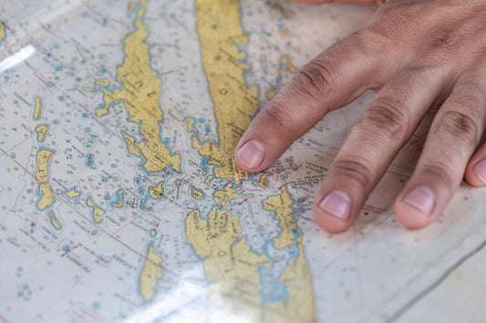 Finger zeigen auf Inseln auf einer Weltkarte